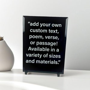 May include: A black acrylic plaque with white text that reads "add your own custom text, poem, verse, or passage! Available in a variety of sizes and materials."