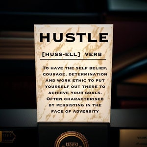 May include: A beige card with a marble-like texture and black text that reads "HUSTLE [HUSS-ELL] VERB To have the self belief, courage, determination and work ethic to put yourself out there to achieve your goals. Often characterised by persisting in the face of adversity."