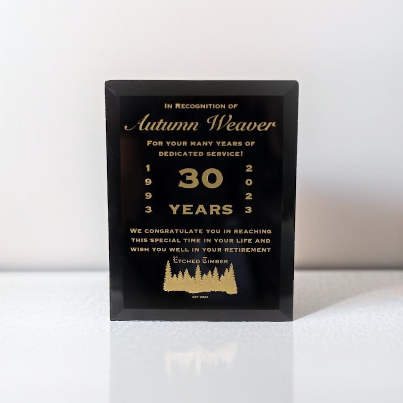 Pu&ograve; includere: Una targa nera con lettere dorate che riconosce Autumn Weaver per 30 anni di servizio dedicato dal 1993 al 2023. La targa include il testo "Ci congratuliamo con lei per aver raggiunto questo momento speciale nella sua vita e le auguriamo buona pensione." e il logo "Etched Timber est 2023."