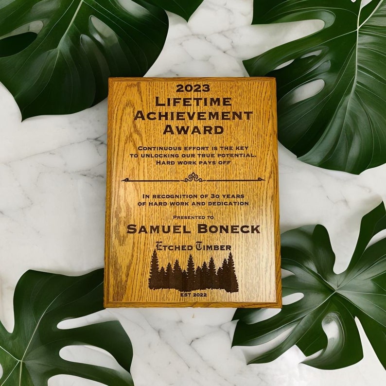Pu&ograve; includere: Una targa in legno con finitura in rovere marrone, incisa con il testo "2023 Lifetime Achievement Award". La targa riconosce Samuel Boneck per 30 anni di duro lavoro e dedizione. La targa &egrave; di Etched Timber, est. 2022.