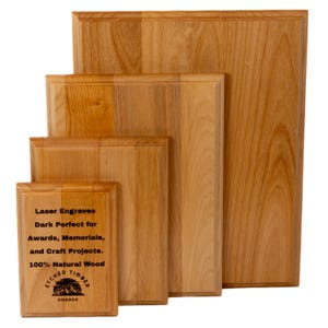 Puede incluir: Cuatro placas de madera de diferentes tamaños, hechas de madera natural. La placa más pequeña tiene el texto "Laser Engraves Dark Perfect for Awards, Memorials, and Craft Projects. 100% Natural Wood" y un logotipo que dice "Etched Timber Awards".