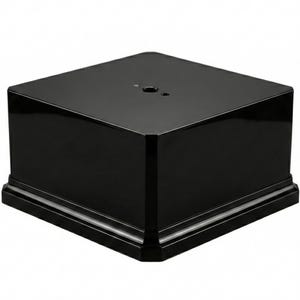 Op de afbeelding: Een glanzende zwarte vierkante displayvoet met een afgeschuinde rand. Het bovenoppervlak heeft een kleine cirkelvormige inkeping. De voet is gemaakt van een solide materiaal en is geschikt voor het presenteren van diverse items.