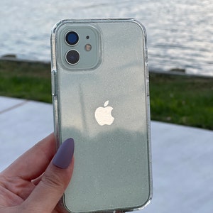 Op de afbeelding: Een transparante telefoonhoes met een lichtgroen glitterontwerp en een zilveren Apple-logo. De hoes is ontworpen voor een iPhone.