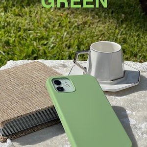 May include: A green silicone phone case for an iPhone with a camera lens cutout.