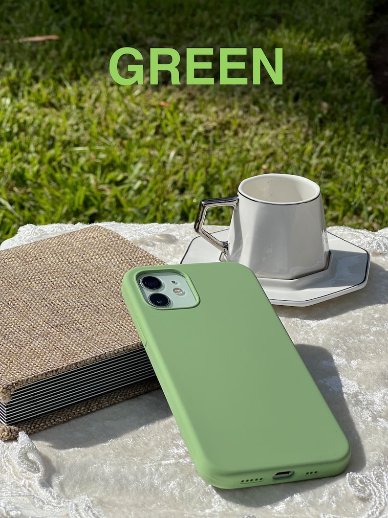 May include: A green silicone phone case for an iPhone with a camera lens cutout.