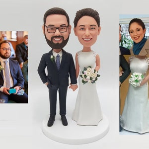 May include: A wedding cake topper featuring a bride and groom in a custom caricature style. The bride is wearing a white wedding dress with a bouquet of white roses. The groom is wearing a dark blue suit with a light blue tie.