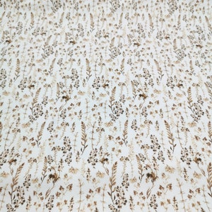 May include: White fabric with a brown floral pattern. The pattern features small, delicate flowers and leaves.