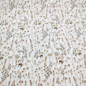 May include: White fabric with a brown floral pattern. The pattern features small, delicate flowers and leaves.