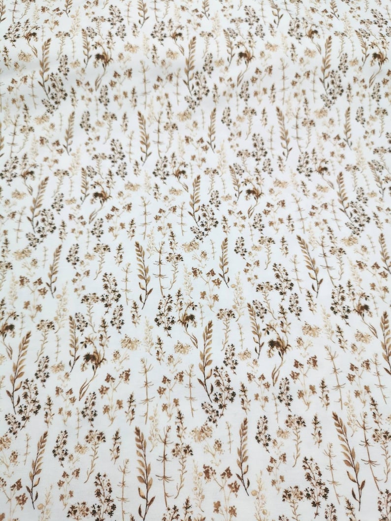 May include: White fabric with a brown floral pattern. The pattern features small, delicate flowers and leaves.