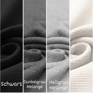 May include: Close-up of four fabric swatches in different colors: black, dark gray, light gray, and ecru. The fabric has a waffle texture.