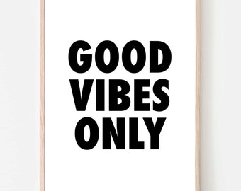 May include: A rectangular wall art print featuring the black text GOOD VIBES ONLY centered on a white background. The print is enclosed in a light-colored wooden frame with a thin profile, creating a clean and simple display for any wall space.