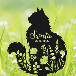 May include: A black metal garden stake shaped like a sitting cat with a long, fluffy tail. The silhouette features cut-out floral patterns and the text "Sweetie" followed by the years "2016-2026" printed in a light yellow script font.