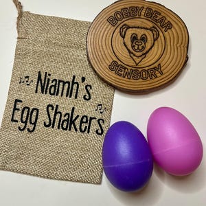 Sac cadeau personnalisé en toile de jute avec shakers à oeufs | Sac cadeau prénom fille | Mes premiers œufs musicaux | Cadeau personnalisé pour bébé | Duo de shakers à oeufs