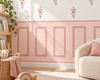 May include: A wall featuring a lower section with pink wainscoting and an upper section with white paint decorated with small, colorful flower decals. The room includes a woven basket with a plush toy, a wooden shelf, and a cream-colored armchair.