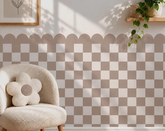 May include: A wall covered in a checkered wallpaper pattern featuring alternating light beige and white squares, finished with a scalloped top edge. A cream-colored, flower-shaped plush pillow sits on a textured, light-colored armchair.