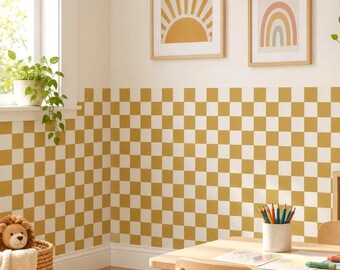 May include: A wall covered in a mustard yellow and white checkered pattern wallpaper. The room features a light wood table with a pencil holder containing colored pencils, a woven basket with a plush lion, and two framed wall art prints.