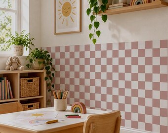 May include: A room featuring a wall covered in a dusty rose and white checkered pattern wallpaper. The space includes a light wood table and chairs, a wooden shelf with a rainbow decor piece, a framed sun print, and potted green plants.