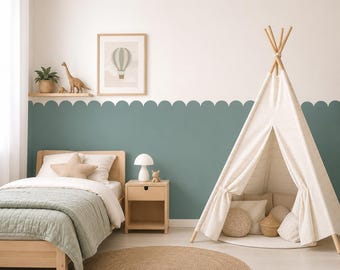 May include: A child's bedroom featuring a light wood bed with a sage green quilt and star pillow, a matching nightstand with a white lamp, a round jute rug, and a white fabric teepee tent. The wall has a sage green scalloped painted border.