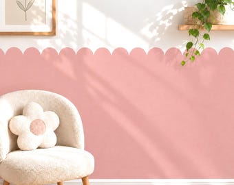 May include: A scalloped wall decal in a solid light pink color applied to the lower portion of a white wall. The design features a continuous rounded edge pattern that creates a decorative border across the wall surface.