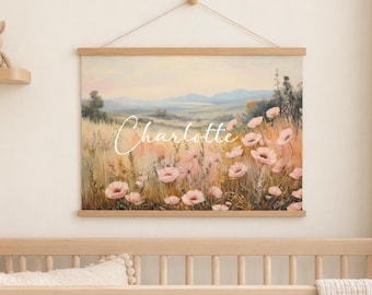 May include: A wall hanging featuring a landscape painting of a field with pink flowers and rolling hills in the distance. The name Charlotte is written in white cursive script across the center of the artwork, which is held by wooden rails.
