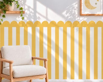 May include: A wall covered in yellow and white vertical striped wallpaper with a scalloped top edge. A framed print featuring a yellow crescent moon and three stars hangs on the wall. A green potted plant sits on a wooden shelf above.