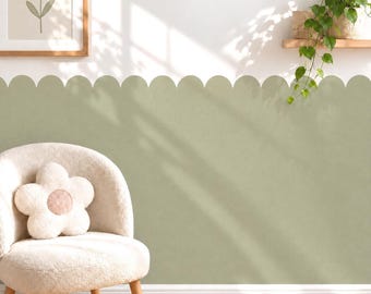 May include: A sage green scalloped wall decal applied to the lower half of a white wall, featuring a smooth matte finish. The design creates a continuous wave pattern along the top edge, providing a clean and decorative border for the room interior.