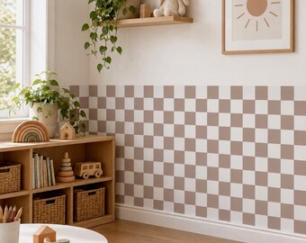 May include: A wall covered in a repeating brown and white checkered pattern wallpaper. The room features a wooden shelving unit filled with woven baskets, books, a wooden rainbow, and a toy car, with a potted plant and a sun print on the wall.