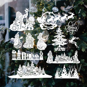 May include: White paper cutouts of Christmas decorations, including Father Christmas, reindeer, a snowman, a Christmas tree, and houses. The cutouts are arranged on a window with a Christmas tree in the background. The text "С Новым Годом" is visible in the image.