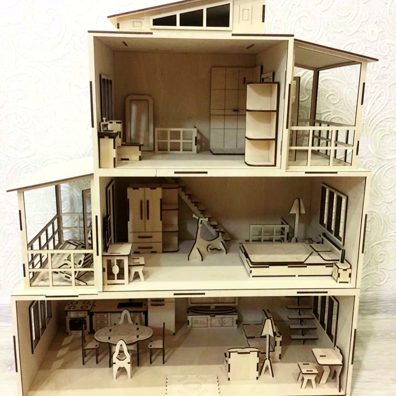 Pu&ograve; includere: Una casa delle bambole in legno con tre livelli, ognuno con stanze diverse. La casa delle bambole &egrave; realizzata in legno chiaro e ha un design semplice. Il livello superiore ha una camera da letto con un letto, una cassettiera e una lampada. Il livello intermedio ha un soggiorno con un divano, un tavolino e una lampada. Il livello inferiore ha una cucina con una stufa, un lavandino e un tavolo con sedie.