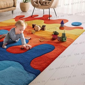 Peut inclure: Un tapis de sol abstrait et coloré avec un design ludique. Le tapis présente un mélange de teintes bleues, rouges, oranges et jaunes. Un bébé joue sur le tapis, entouré de jouets. La forme unique et les couleurs vives du tapis créent un espace moderne et accueillant.