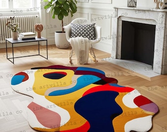 May include: A colorful, abstract area rug with a unique, organic shape. The rug features a vibrant mix of colors, including blue, yellow, red, and white, creating a modern and artistic design. The rug is placed on a wooden floor.