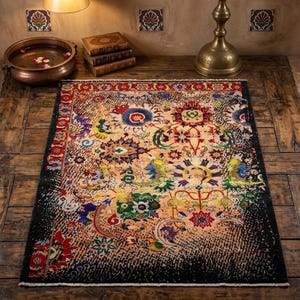 May include: A rectangular, intricately patterned rug with a black border. The rug features a central design with floral and paisley motifs in shades of red, blue, green, and yellow on a beige background. The rug is placed on a wooden floor.