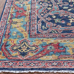 May include: A blue, red, and yellow patterned rug with a fringed edge. The rug has a traditional Persian design with intricate details.