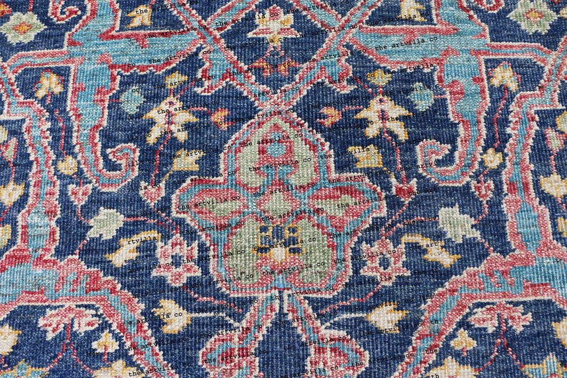 May include: Close-up of a blue rug with a floral pattern. The rug has a detailed design with intricate details in shades of pink, blue, and yellow.