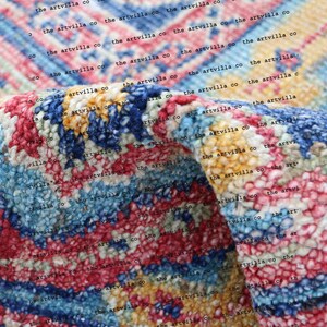 May include: Close-up of a colorful, textured rug with a repeating pattern. The rug is made of a soft, fuzzy material and has a variety of colors, including blue, pink, yellow, and white. The text "the artvilla co" is repeated throughout the image.