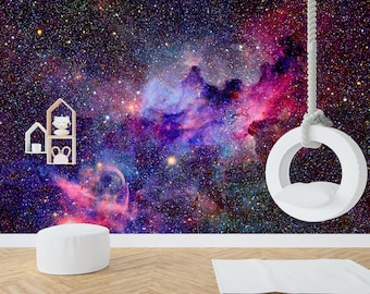 May include: A white swing hanging from the ceiling against a backdrop of a galaxy space scene with pink, purple, and blue nebulae. The swing is made of a white ring with a white cushion.