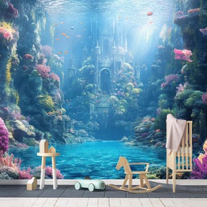 Pode incluir: Um vibrante papel de parede com uma cena subaquática com um castelo, corais e peixes. O papel de parede tem um esquema de cores azul e verde-azulado. Um cavalo de baloiço de madeira, um berço e uma pequena mesa estão em primeiro plano.