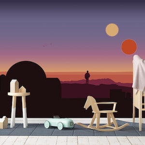 Op de afbeelding: Een kinderkamer met een muurschildering van een zonsondergang boven een woestijnlandschap. Een houten schommelpaard, een wieg en een speelgoedauto staan voor de muurschildering. Een kleine houten tafel draagt miniatuurhuisjes.