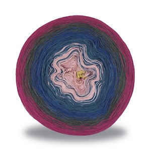 Op de afbeelding: Een ronde bol garen met een kleurenschema. Het garen gaat over van een diep magenta naar tinten blauw, grijs en roze in het midden. Een kleine goudkleurige bedel bevindt zich in het midden van de bol. Het garen is waarschijnlijk om te breien of te haken.