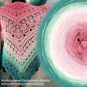 Può includere: Uno scialle triangolare all'uncinetto con un intricato motivo in pizzo e una sfumatura di colore che va dal verde acqua scuro in basso al rosa chiaro in alto, mostrato accanto a un gomitolo di lana rotondo abbinato con un piccolo ciondolo a cuore.