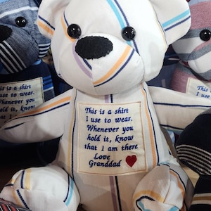 May include: A white teddy bear made from striped fabric with a heart and the text "This is a shirt I use to wear. Whenever you hold it, know that I am there Love Granddad" embroidered on its chest.