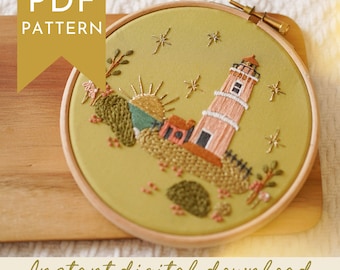 May include: An embroidery hoop featuring a lighthouse scene with a rising sun, stars, and small buildings. The design is stitched on a green fabric and framed in a wooden hoop. Text on the image reads "PDF PATTERN" and "Instant digital download."