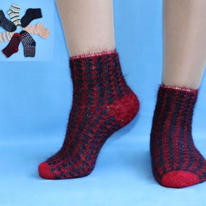 Puede incluir: Se muestra un par de calcetines tobilleros con estampado rojo y negro en los pies de una persona. Los calcetines tienen una apariencia texturizada y un puño, talón y puntera rojos. Se muestran varios pares de calcetines en la esquina superior izquierda.
