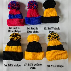 May include: Six knitted hats with pom-poms in various color combinations: red and blue, black and yellow. The hats are labeled with descriptions like "Red & Blue stripe", "B&Y black Pom", and "Y&B stripe".