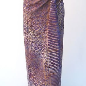 Könnte beinhalten: Lila und goldfarbener Sarong mit einem Knoten in der Taille.