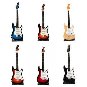 Könnte beinhalten: Sechs E-Gitarren in verschiedenen Farben, darunter Blau, Rot, Schwarz und Naturholz. Die Gitarren sind alle im gleichen Stil, mit einem einteiligen Korpus und einem Hals mit sechs Saiten.