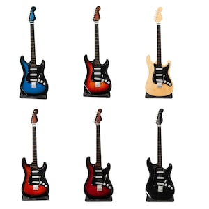 Könnte beinhalten: Sechs E-Gitarren in verschiedenen Farben, darunter Blau, Rot, Schwarz und Naturholz. Die Gitarren sind alle in einem ähnlichen Stil gehalten, mit einem einteiligen Korpus und einem sechssaitigen Hals.