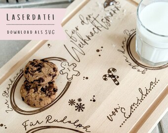 May include: A wooden serving tray with a Christmas theme. The tray has a gingerbread man, candy cane, and snowflakes engraved on it. It also has the text "Für den Weihnachtsmann von Emilia" and "Für Rudolph". There are two chocolate chip cookies, a carrot, and a glass of milk on the tray.