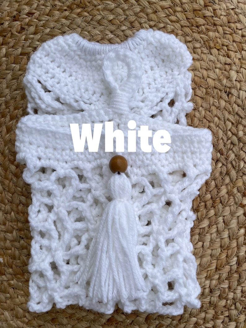 May include: White crocheted bag with a wooden bead and tassel. The bag has a lacy design and is perfect for carrying small items.