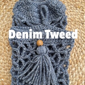 May include: A crocheted bag with a denim tweed texture and a wooden bead tassel. The bag is blue and white and has a woven pattern. The text "Denim Tweed" is written in white letters on a black background.